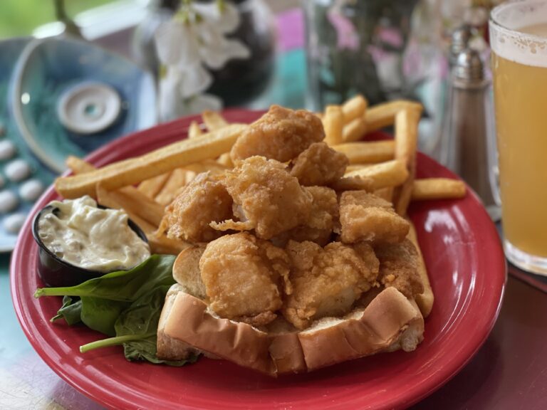 A pint of New Bedford scallops deep fried and loaded into a grilled hot dog roll, fries and tartar on the side
