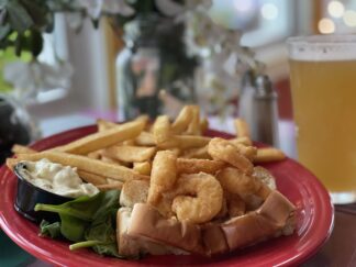 Crispy battered shrimp in a grilled roll with fries and tartar on the side