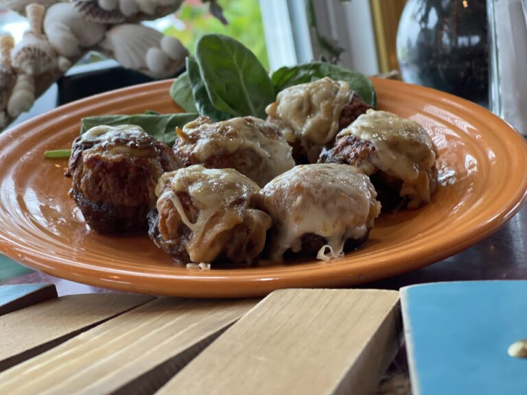 Button mushroom caps stuffed with savory herbs and Ritz , baked under melty mozzarella, and a gentle, tangy sauce